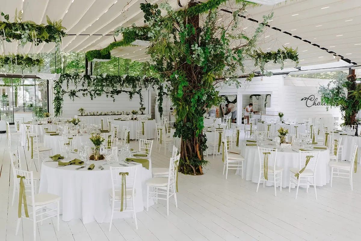 Chalette Events (Păun, Iași): salon alb cu copac decorativ în centru și mese rotunde