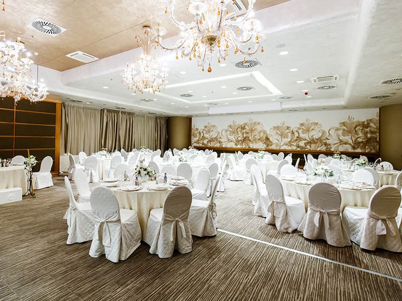Congress Hall (Iași): sala de nuntă cu huse albe pe scaune și candelabre