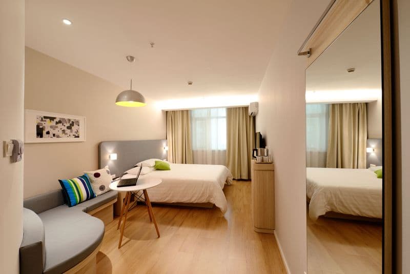 Cameră de hotel luminoasă, cu pat dublu și canapea